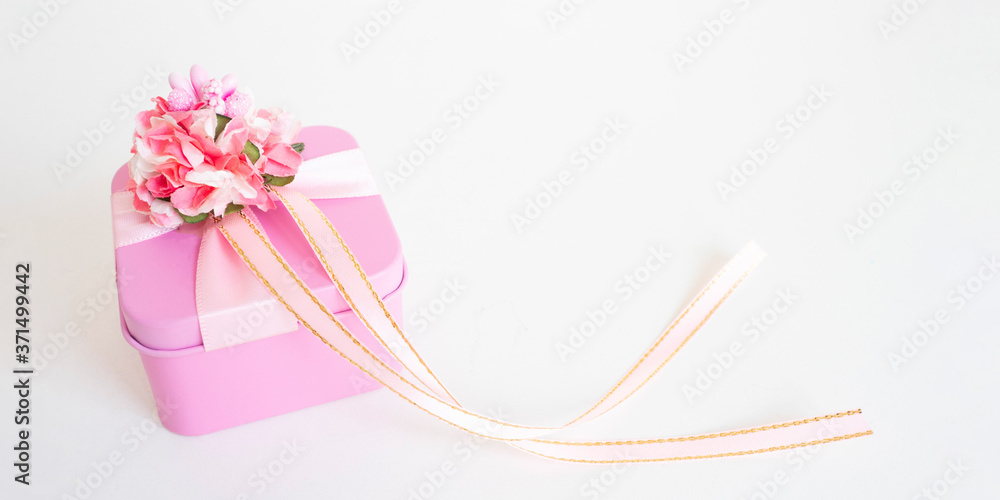 banner: pink gift box with a flower and ribbons on a white background. copy space..