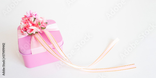 banner: pink gift box with a flower and ribbons on a white background. copy space..