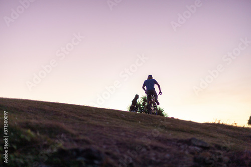 Two cyclists riding bikes at sunset © JRstock