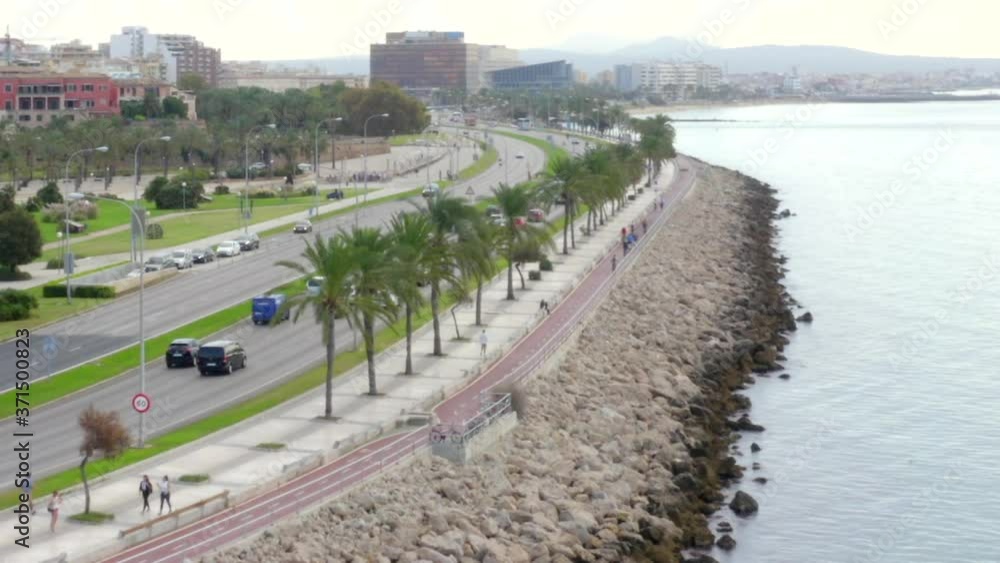 AERIAL: Coast road with cars, traffic on ocean with Palm trees on Tropical Island Mallorca, Spain on Sunny Day Vacation, Travel, Sunny AERIAL: Coast road with cars, traffic on ocean with Palm trees on Tropical Island Mallorca, Spain on Sunny Day Vacation, Travel, Sunny