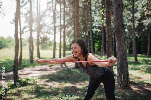 Young Caucasian woman exercising with elastic band at the public park