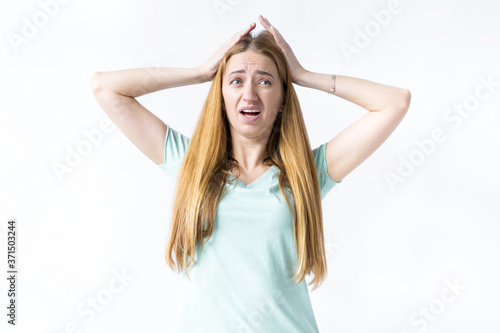 Portrait of a girl, she is holding her head with both hands and screaming in surprise and complete bewilderment, shocked by the big sales on the websites of online stores