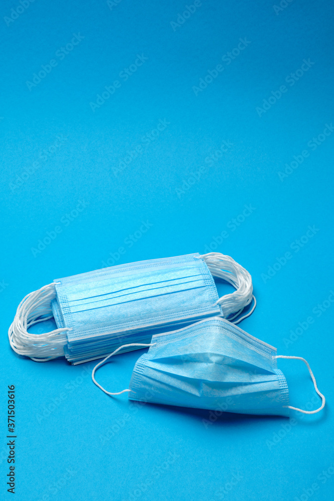 Stack of Disposable blue medical face masks on blue background Stack of Disposable blue medical face masks on blue background