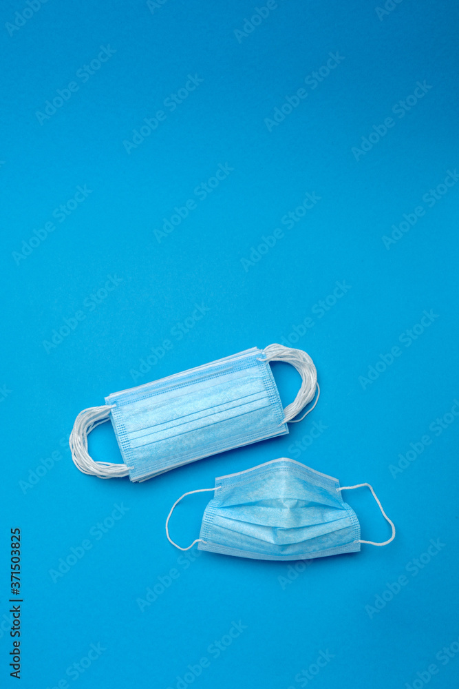 Stack of Disposable blue medical face masks on blue background Stack of Disposable blue medical face masks on blue background