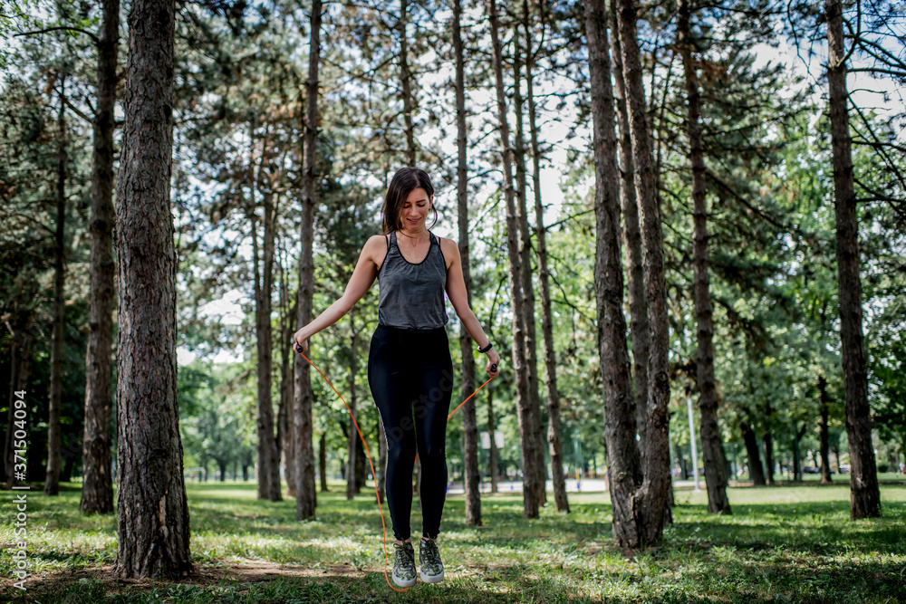 Young woman exercising with jumping rope at public park Young woman exercising with jumping rope at public park