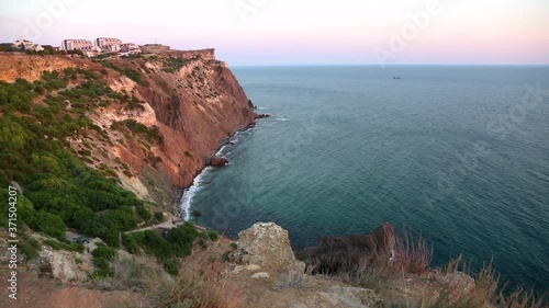 Lukull cape is a high long red rocky cliff.It is located near the city of Sevastopol in the Crimea. The sea surf never stops here. photo