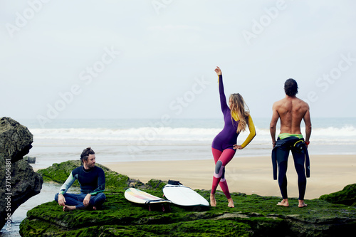 Photography International group of friends having fun waiting big waves for surfing