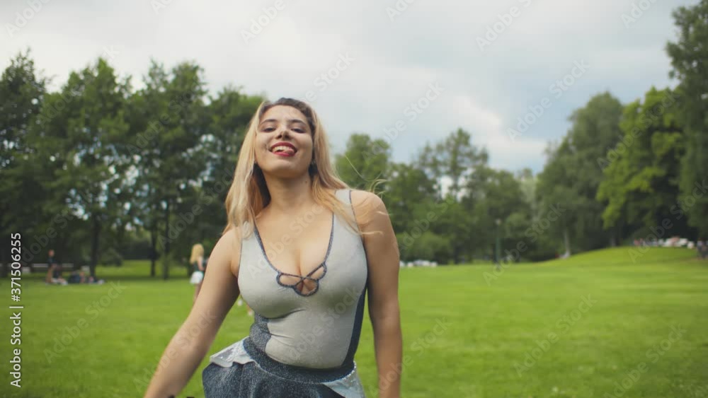 Portrait of happy cheerleader woman dancing with pom-poms in park Portrait of happy cheerleader woman dancing with pom-poms in park