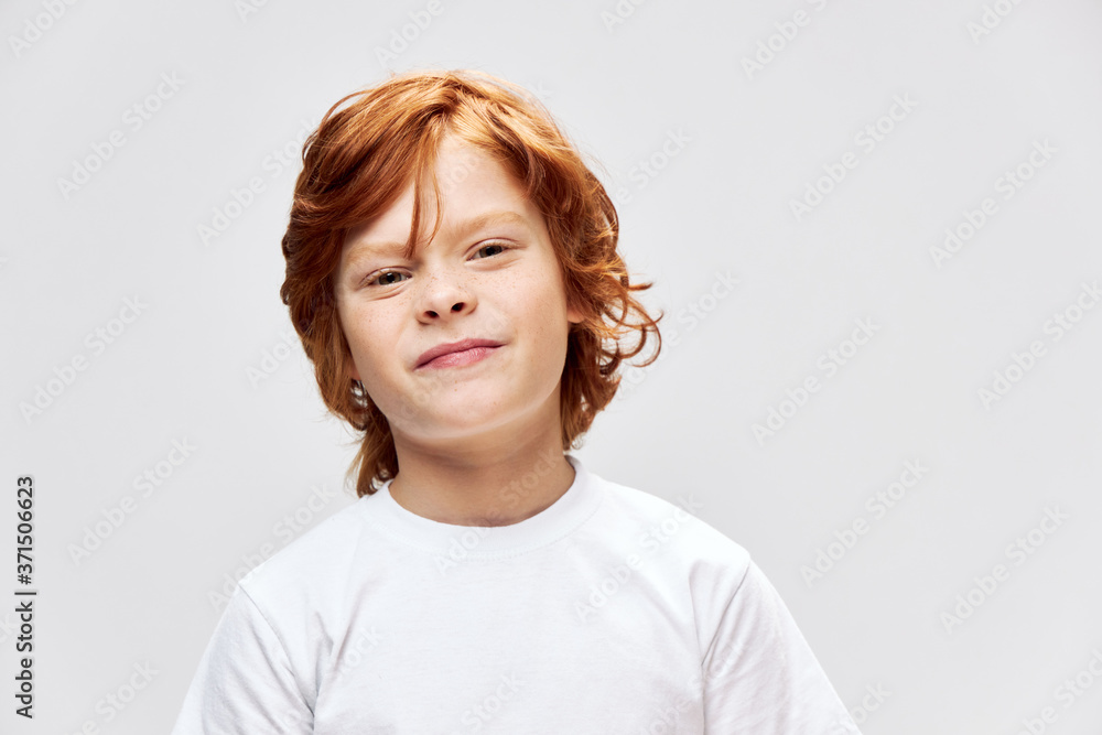 Redhead boy with displeased facial expression face close up cropped view Redhead boy with displeased facial expression face close up cropped view