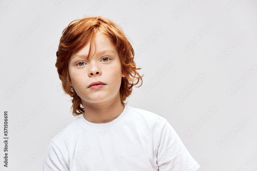 Portrait of a red-haired boy in a white T-shirt face close-up Portrait of a red-haired boy in a white T-shirt face close-up
