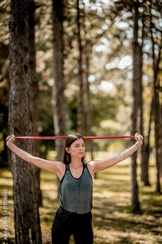 Young Caucasian woman exercising with elastic band at the public park