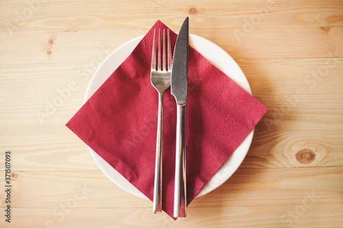 Close up of silverware, napkin and side plate