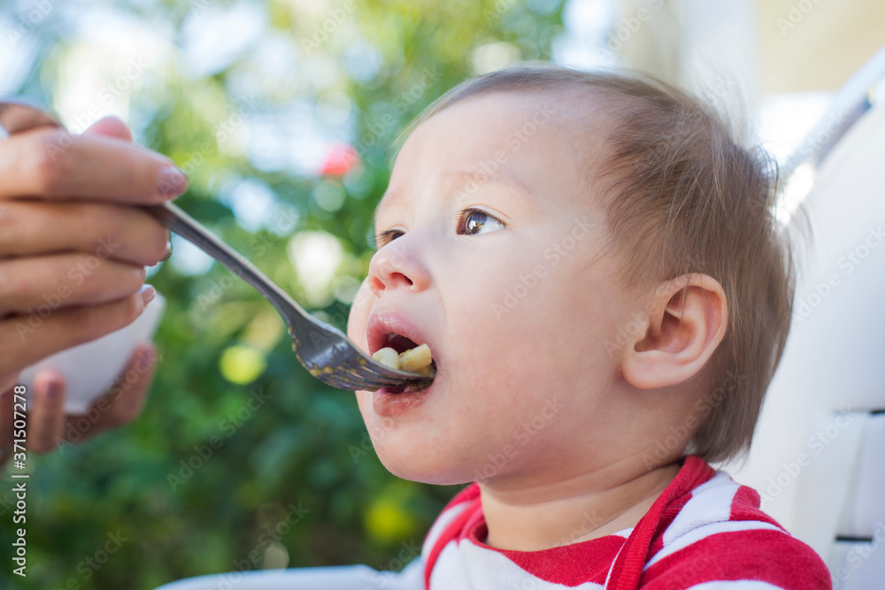 Mixed race mother feeding baby outdoors Mixed race mother feeding baby outdoors