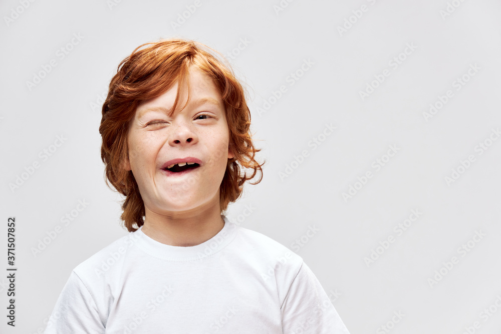 Cheerful redhead child white t-shirt smile Studio gray isolated Cheerful redhead child white t-shirt smile Studio gray isolated