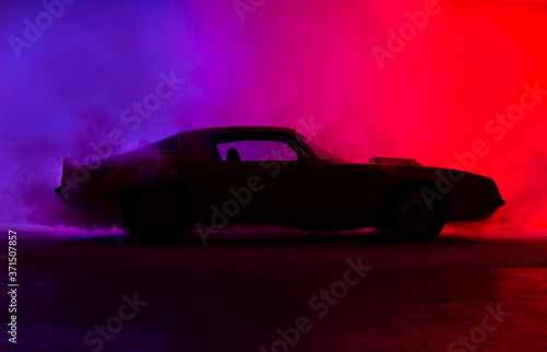 Silhouette of an old fashion muscle car on a red background..