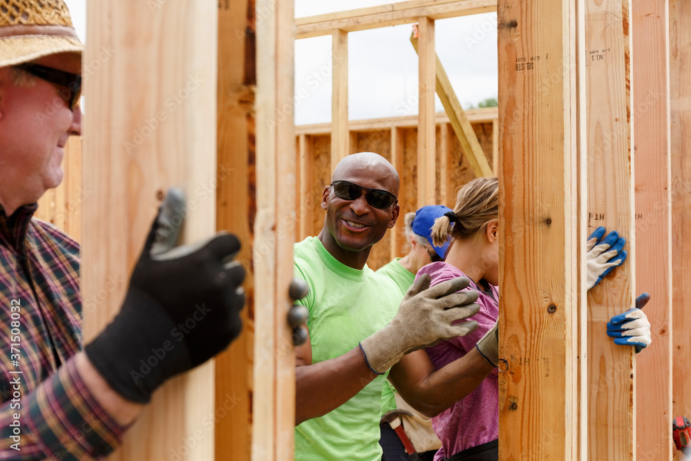 Volunteers holding wall at construction site Volunteers holding wall at construction site