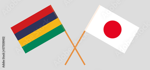 Crossed and waving flags of Mauritius and Japan