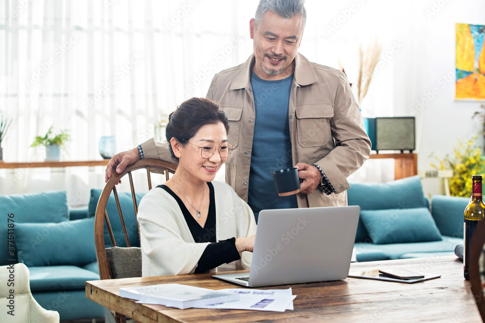 Happy old couple using laptop at home Happy old couple using laptop at home