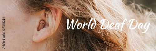 small intra channel hearing aid in the ear of a woman. banner. text "World Deaf Day" OFL font