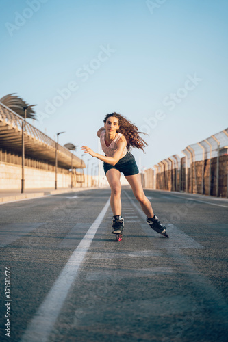 Young woman inline skating on boardwalk at the coast