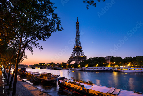 Eiffel Tower by Seine river against clear blue sky at sunset, Paris, France photo