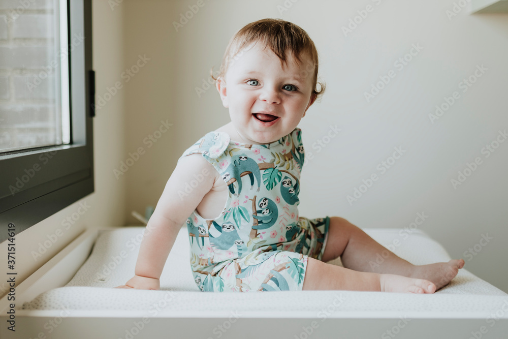 Cute happy baby girl sitting on table at home Cute happy baby girl sitting on table at home