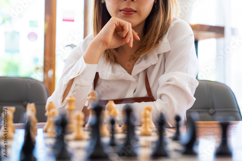 Woman playing chess in club, leisure activity of weekend and compitetion concept. photo