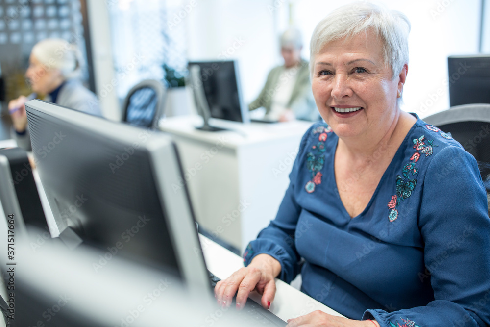 Confident enior woman attending computer course Confident enior woman attending computer course