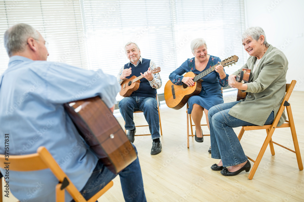 Seniors in retirement home attending guitar class, making music Seniors in retirement home attending guitar class, making music
