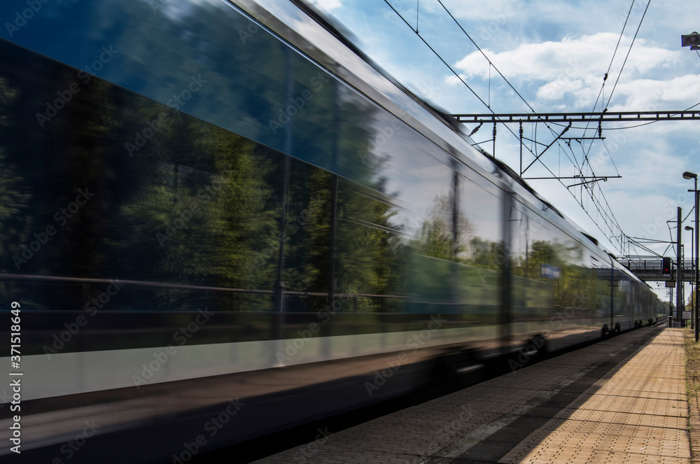Fototapeta premium Train in movement by rail with a blue sky