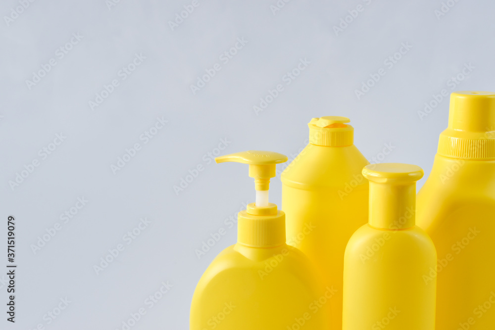 Four yellow plastic bottles on a white background on the right side Four yellow plastic bottles on a white background on the right side