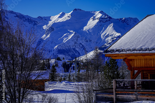 Wooden Ski Chalet In Snow  Mountain View. Beautiful view of French Alps full of snow winter. Food prints in the snow