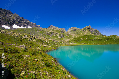 Fototapeta Naklejka Na Ścianę i Meble -  Alpine mountain lake at the daytime, sunlight and colorful landscape