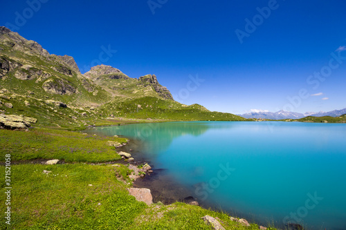 Alpine mountain lake at the daytime, sunlight and colorful landscape