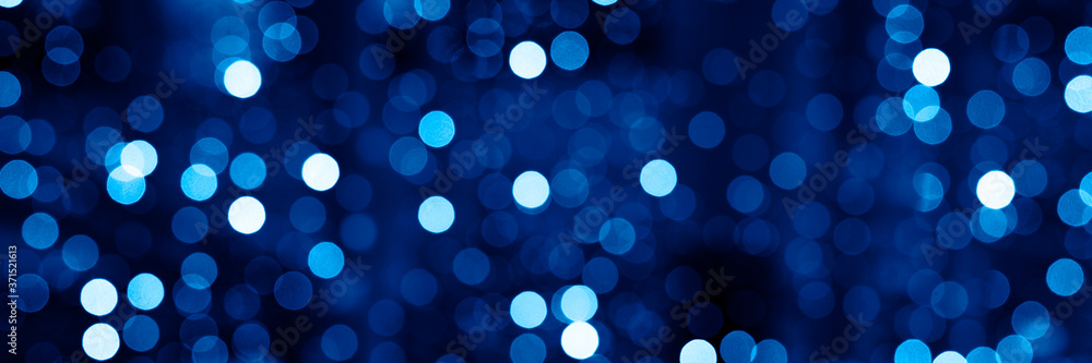 blurred glowing lights of garlands of classic blue color, bokeh. banner blurred glowing lights of garlands of classic blue color, bokeh. banner