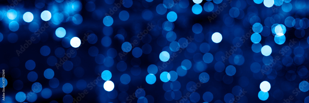 blurred glowing lights of garlands of classic blue color, bokeh. banner blurred glowing lights of garlands of classic blue color, bokeh. banner