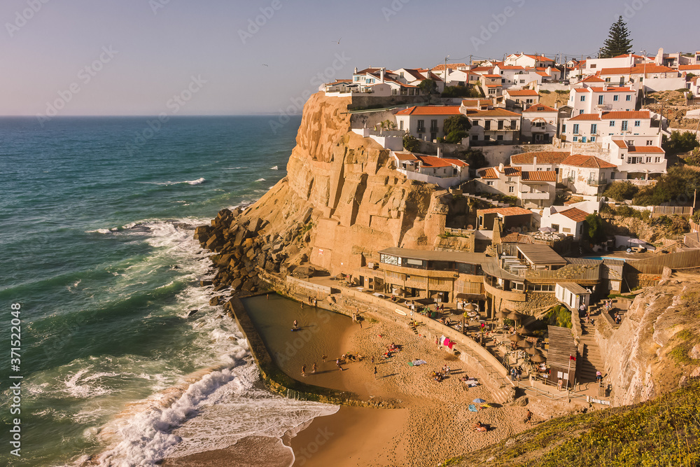 View of the picturesque village of Azenhas do Mar, in the Sintra region, in Portugal, 35 minutes away from Lisbon, with the famous stacked houses and ocean pool. Travel photo concept