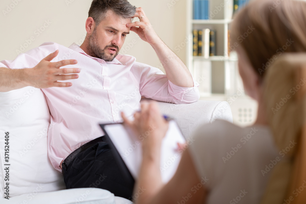 Fototapeta premium Handsome stressed businessman during meeting with his therapist