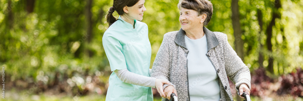 Senior disabled woman with caregiver in the garden of the nursin Senior disabled woman with caregiver in the garden of the nursin