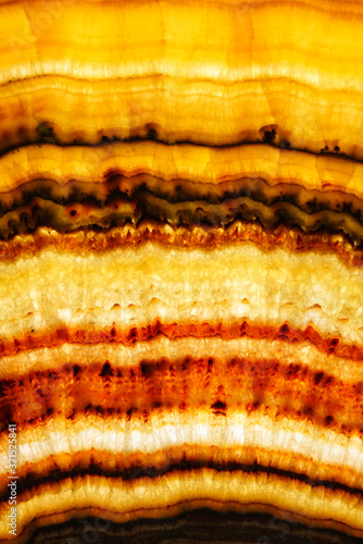 Backlit layered red and yellow marble onyx. Close up detai