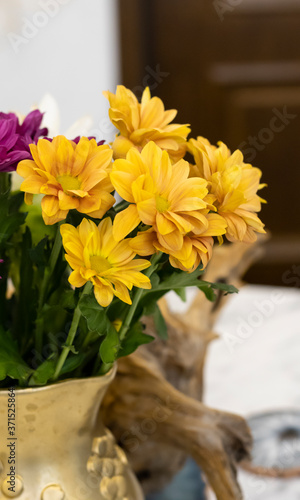 Apartment interior with flowers. Chrysanthemum flowers in a vase on a marble table.