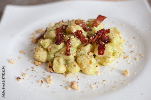 Still life cibo, piatti da ristorante. Food service e fotografie gustose di primi piatti fatti in casa, gnocchi handmade pancetta, guanciale, pistacchio e pan grattato. photo