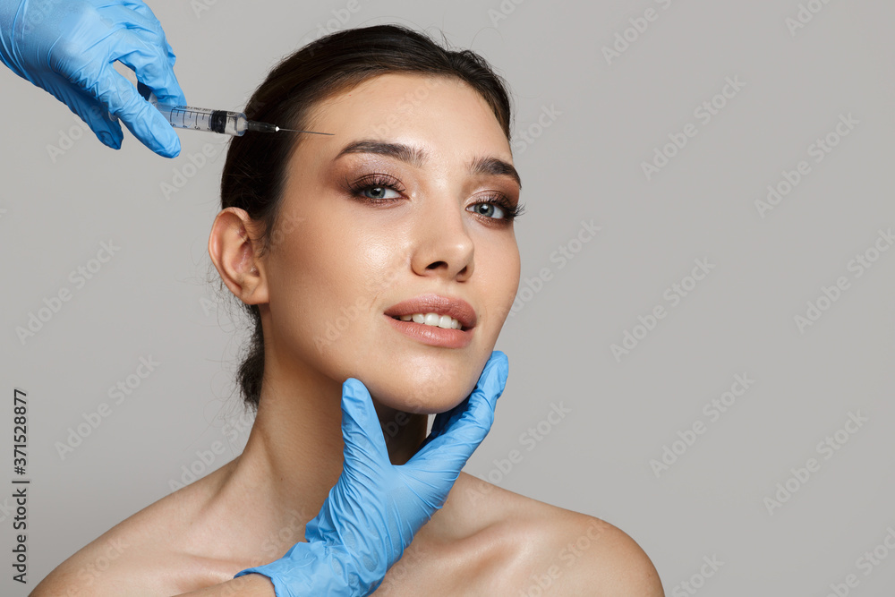 Portrait of a smiling woman with clean skin. Mesotherapy needle insertion. Copycpase