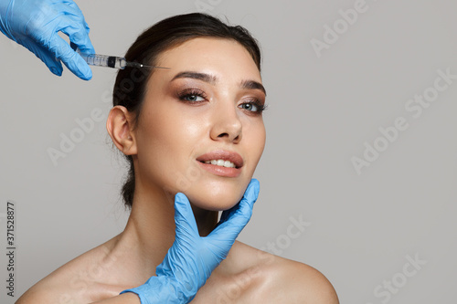 Portrait of a smiling woman with clean skin. Mesotherapy needle insertion. Copycpase photo