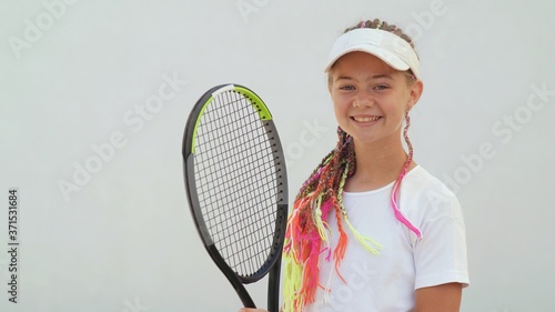 Portrait of a young girl with dreadlocks and a tennis racket on a white background. © Довидович Михаил