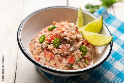 Canned tuna ceviche with chili pepper and tomato on white background