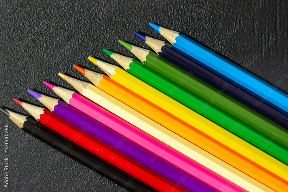 Set of colored pencils on a black background. Colored pencils on a chalk board. Black texture with colored pencils. Harsh texture Set of colored pencils on a black background. Colored pencils on a chalk board. Black texture with colored pencils. Harsh texture