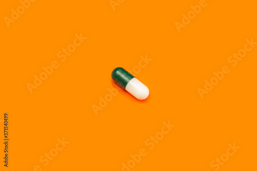 Green pill on orange background. White pill on yellow background. Orange seamless pattern and green pill.
