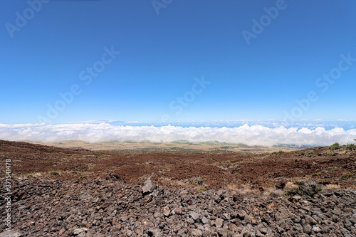 View from the mountain side of Mauna Kea on Hawaii Island looking out over Waimea Valley at the cloud banks almost covering the Pacific ocean.