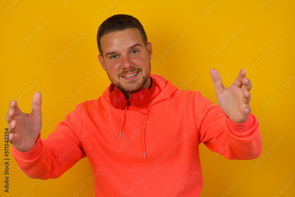 Cheerful man making a welcome gesture raising arms over head isolated on white background. Cheerful man making a welcome gesture raising arms over head isolated on white background.